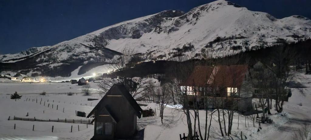 una casa nella neve con una montagna sullo sfondo di Koliba Činčila a Žabljak