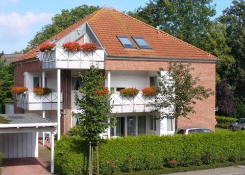 une maison avec des boîtes de fleurs à l'avant dans l'établissement Strandrose, à Horumersiel