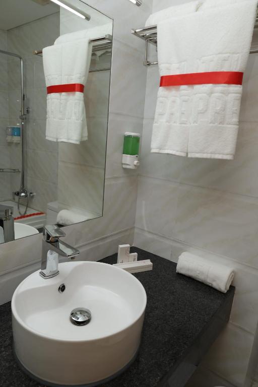 y baño con lavabo blanco y espejo. en Hotel Express en Luanda