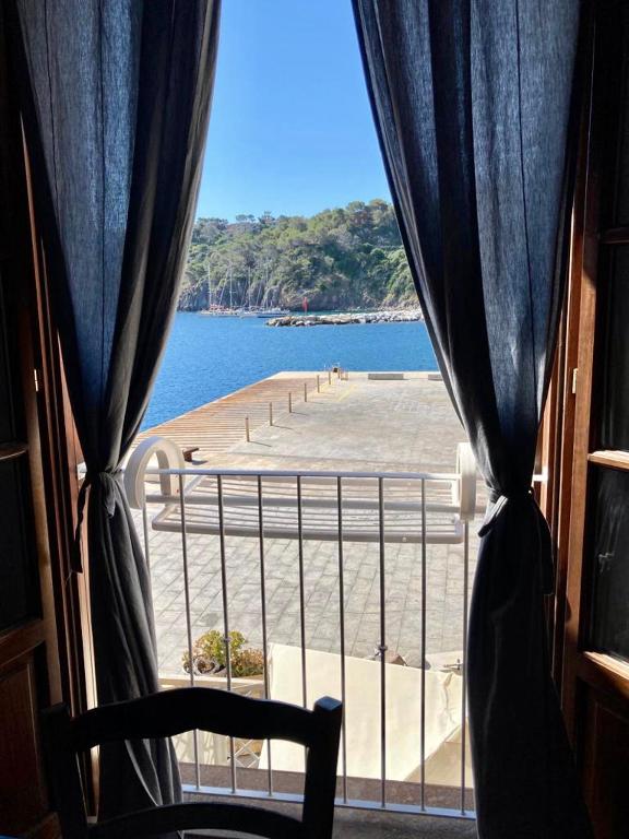 a view of a beach from a window with a chair at Sea View Apartment in Capraia