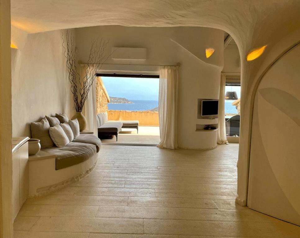 sala de estar con sofá y vistas al océano en SAN TEODORO PUNTA EST FANTASTICO TRILOCALE VISTA MARE en Capo Coda Cavallo