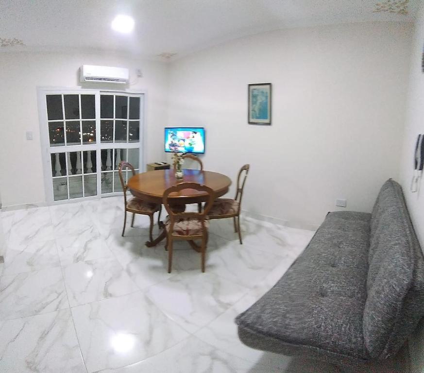 een woonkamer met een tafel en een bank bij Departamento 51 TORRE PARIS in Resistencia