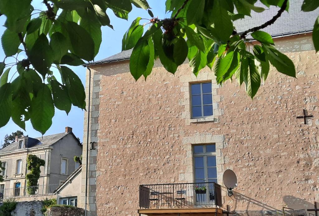 - un bâtiment en briques avec une fenêtre sur le côté dans l'établissement Loire Valley village centre apartment chezANIA, à Le Grand-Pressigny