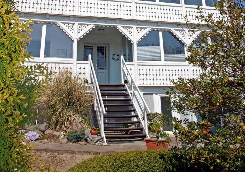 a white house with a staircase leading to the front door at Ferienzimmer in der Villa Ostseelilie in Sassnitz