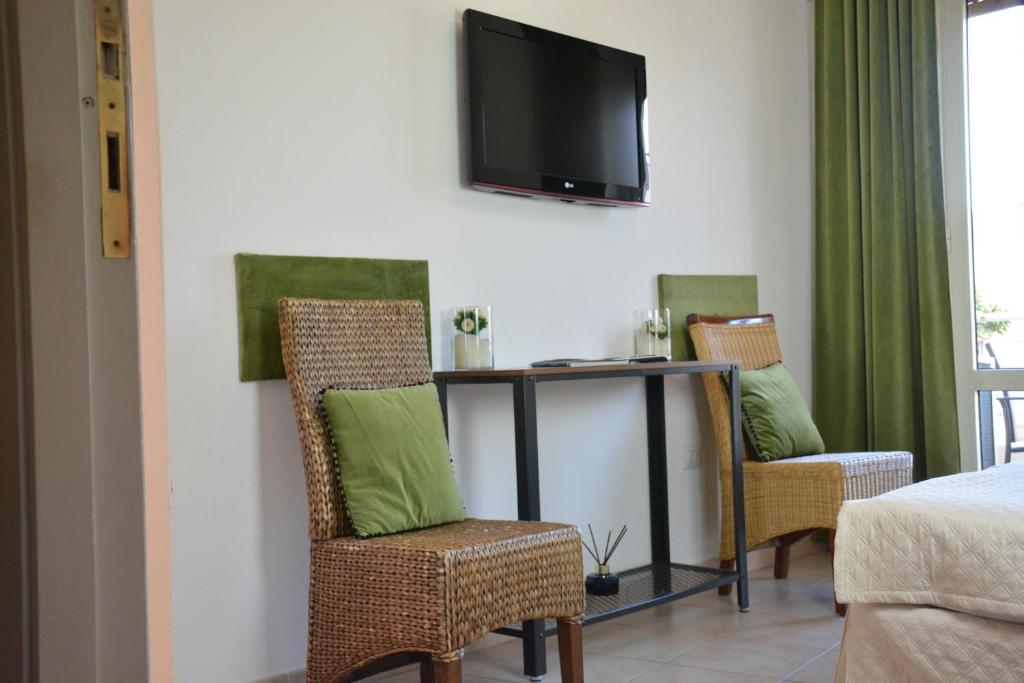 une chambre avec deux chaises et une table avec une télévision dans l'établissement B&B Fashion style, à Cagliari