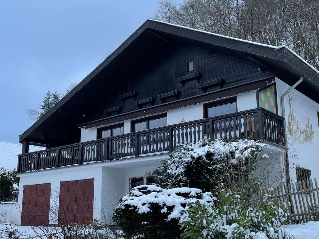 Feusdorf的住宿－Ferienhaus Eifelblick，白色和黑色的房子设有阳台