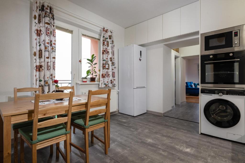 a kitchen and dining room with a wooden table and chairs at Apartmán LM in Liptovský Mikuláš