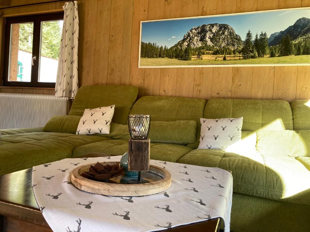 a living room with a green couch and a table at Chalet Wildalpen (in Ruhelage & mit Wellness) in Wildalpen