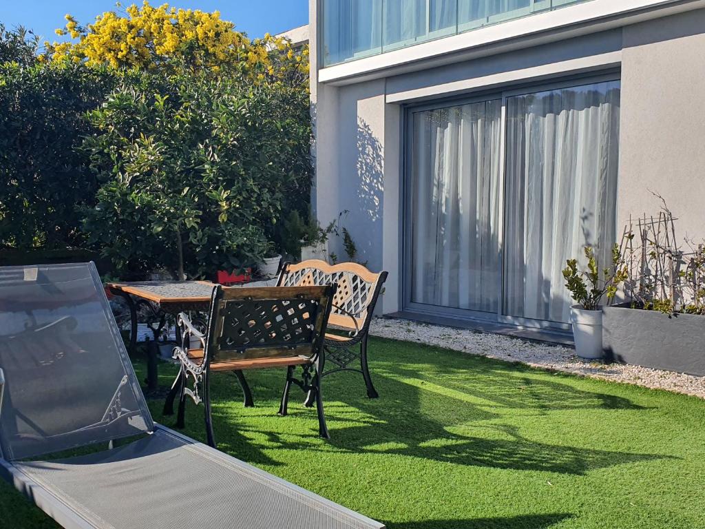césped con mesa, sillas, mesa y sillas en Villa HARMONY, en Vallauris