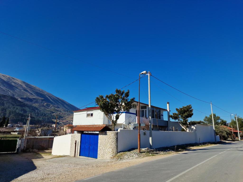 an empty street with a white house and a street light at Guest House KrisHen in Përmet