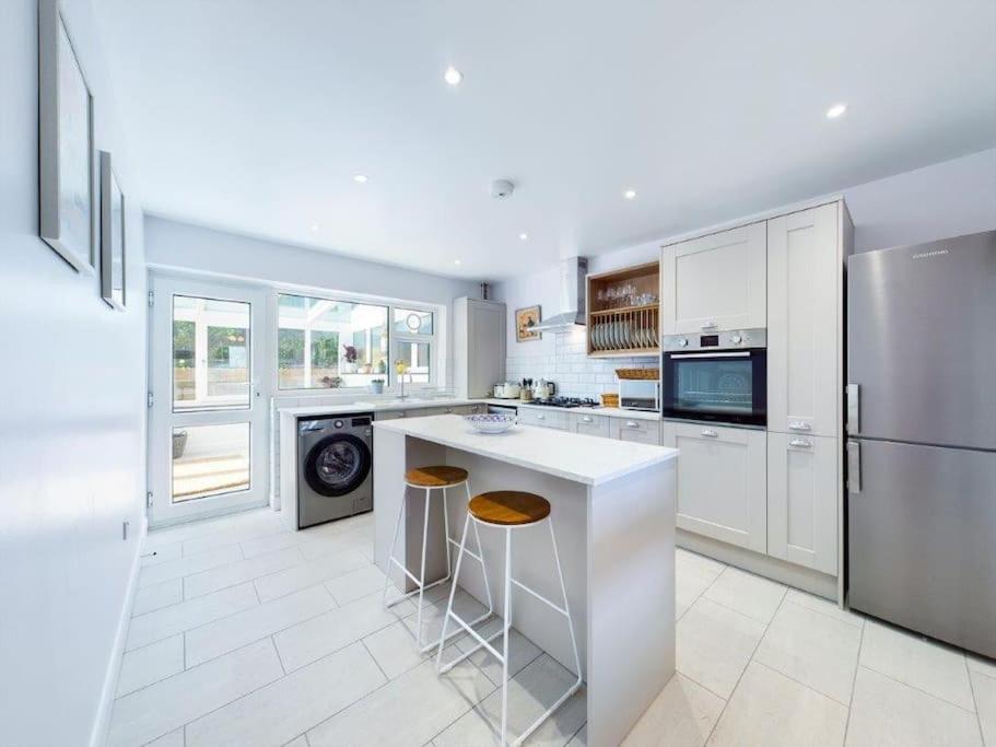 a white kitchen with a counter and a refrigerator at Broadstairs Beach Bungalow. Dogs welcome! in Broadstairs