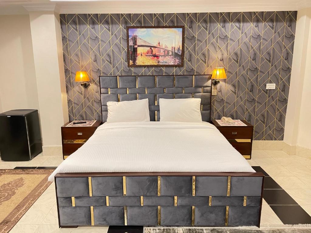 a bedroom with a large bed and two night stands at Arya Hotel Islamabad in Islamabad