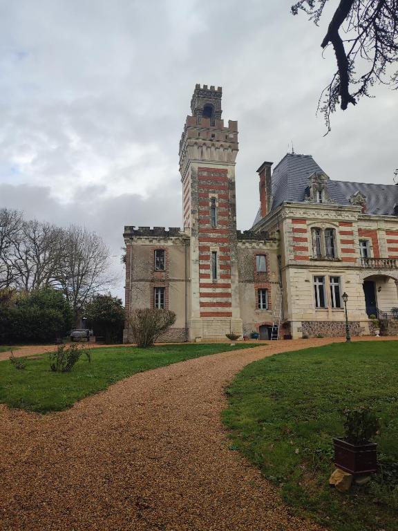 stary budynek z wieżą na górze w obiekcie la tour carrée d'un chateau w mieście Auzouer-en-Touraine