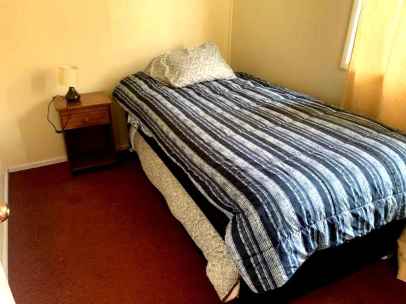 1 cama con edredón a rayas en un dormitorio en Shofia3, en Valdivia
