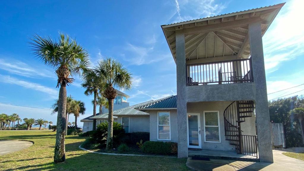 a house with palm trees in front of it at JEKYLL KEEPERS QUARTERS apts in Jekyll Island