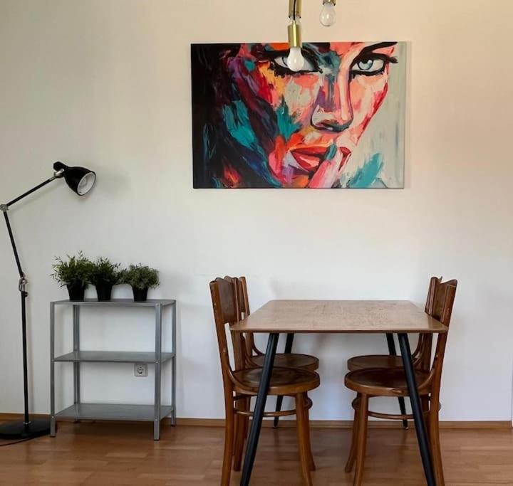 uma mesa e cadeiras num quarto com uma pintura em Cozy City Center Apartment em Graz