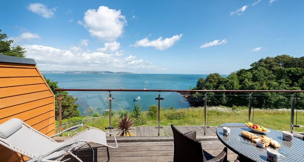 a patio with a table and chairs and a view of the water at Osprey 2 - The Cove in Brixham