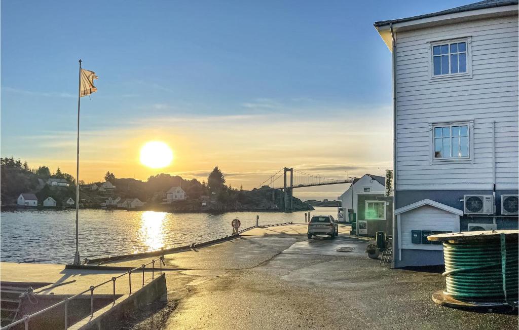 a building next to a body of water with the sunset at 4 Bedroom Beautiful Apartment In Herdla in Herlø