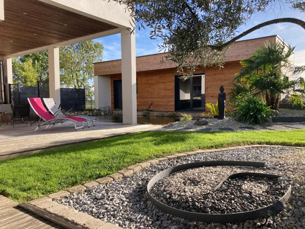 un patio trasero con una hoguera en el césped en Adorable Studio d'hôte zen et paisible, en Les Gonds
