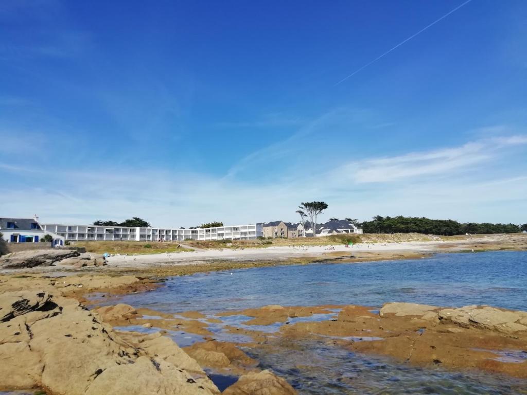 een uitzicht op het strand met gebouwen op de achtergrond bij Vue Belle île in Quiberon