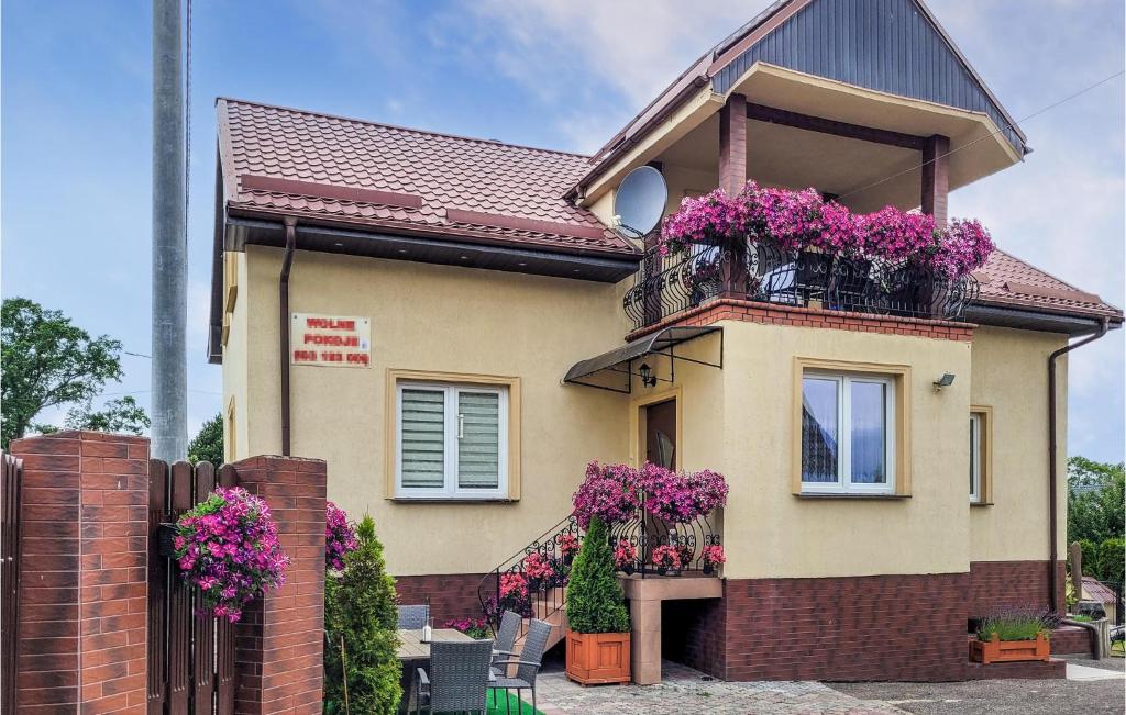 a house with purple flowers on the balcony at Amazing Home In Darlowo With Outdoor Swimming Pool in Darłowo