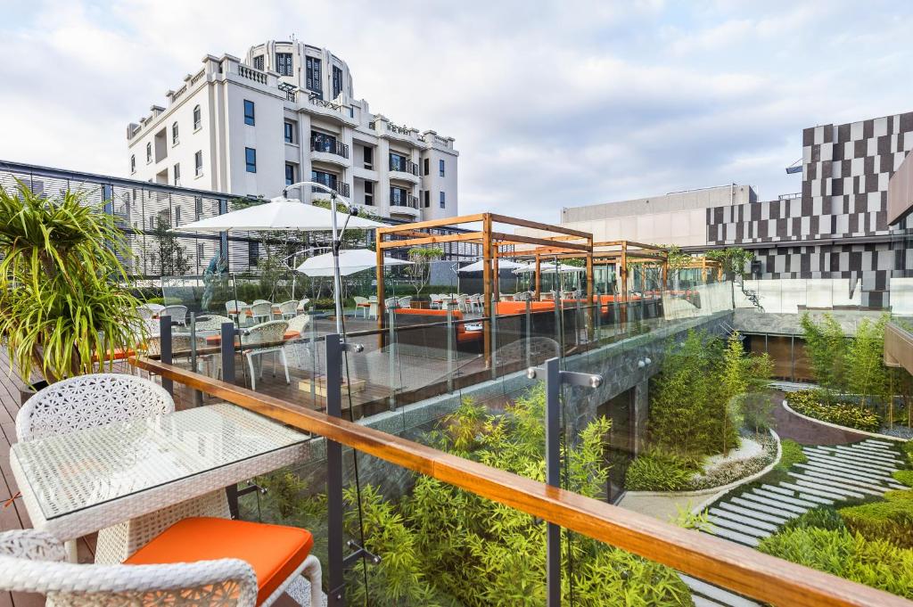 a balcony with tables and chairs on a building at In Sky Hotel in Taichung