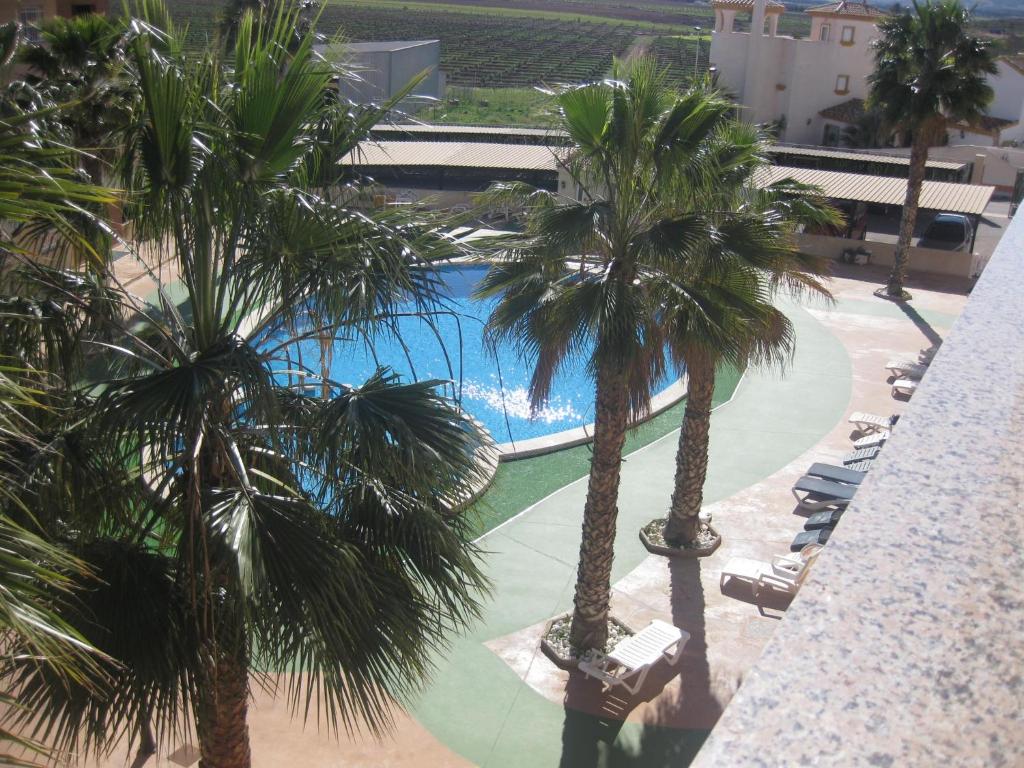 una persona que toma una foto de una piscina con palmeras en APARTAMENTO PALMERAL DEL MAR MENOR, en Los Nietos