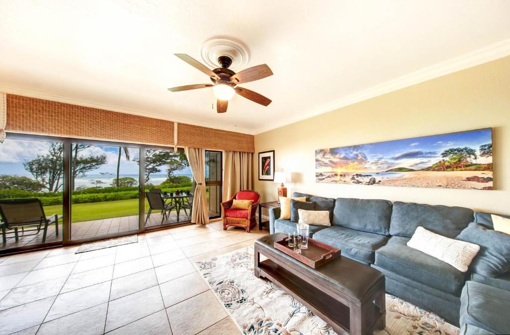 sala de estar con sofá azul y ventilador de techo en Kauai Kaha Lani by Coldwell Banker Island Vacations, en Lihue