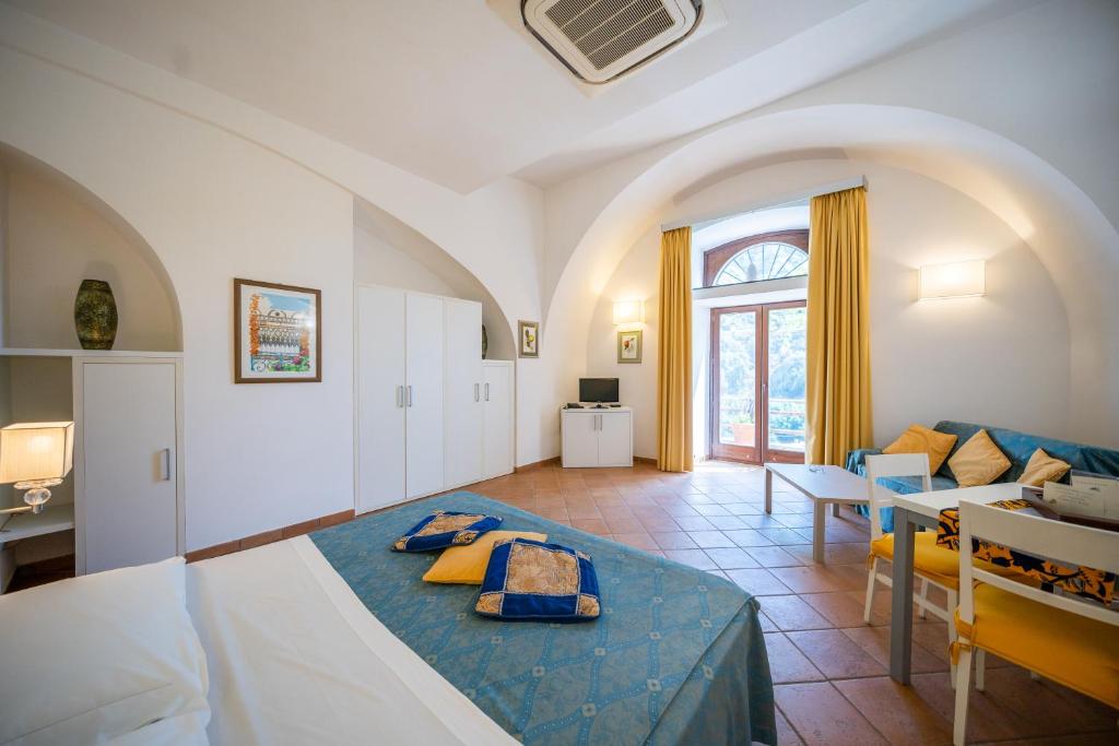 a living room with a bed and a dining room at Limoneto Di Ercole in Maiori