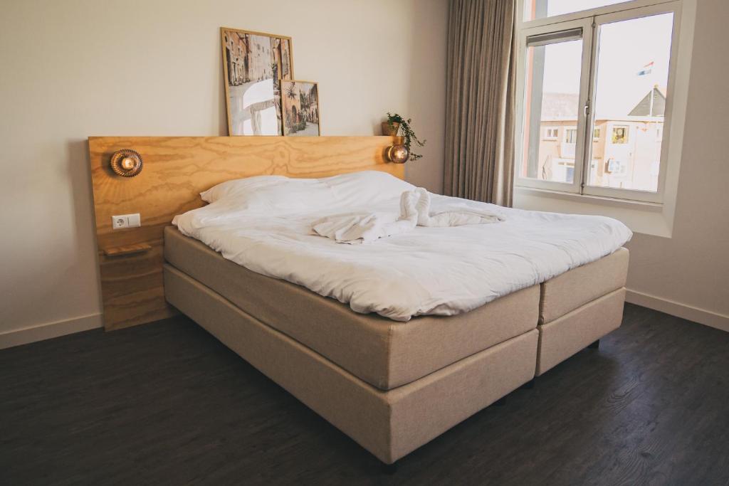 ein großes Bett in einem Zimmer mit Fenster in der Unterkunft Hotel restaurant SAM in Tholen