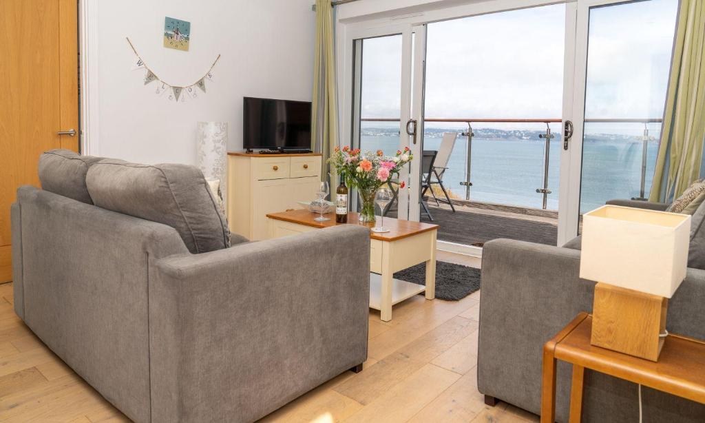 a living room with two couches and a view of the ocean at Puffin 4 - The Cove in Brixham
