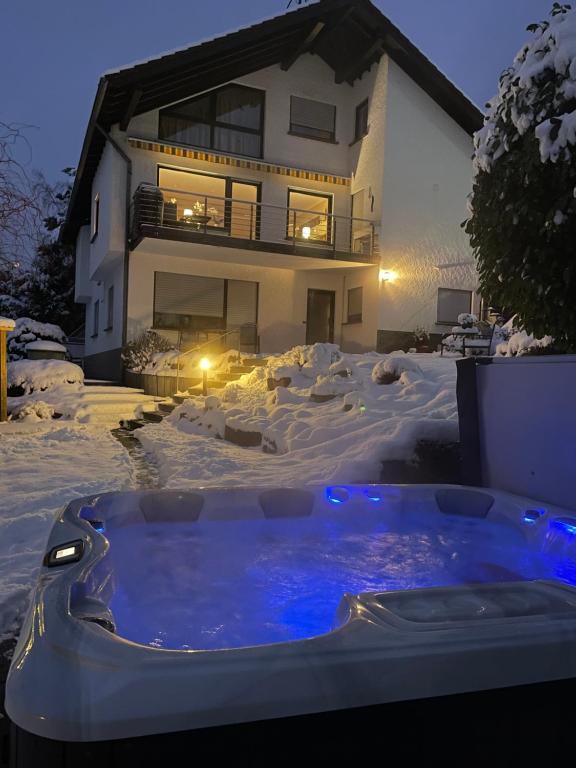 Un jacuzzi en la nieve frente a una casa en Gästehaus Ute Müller, en Wimbach