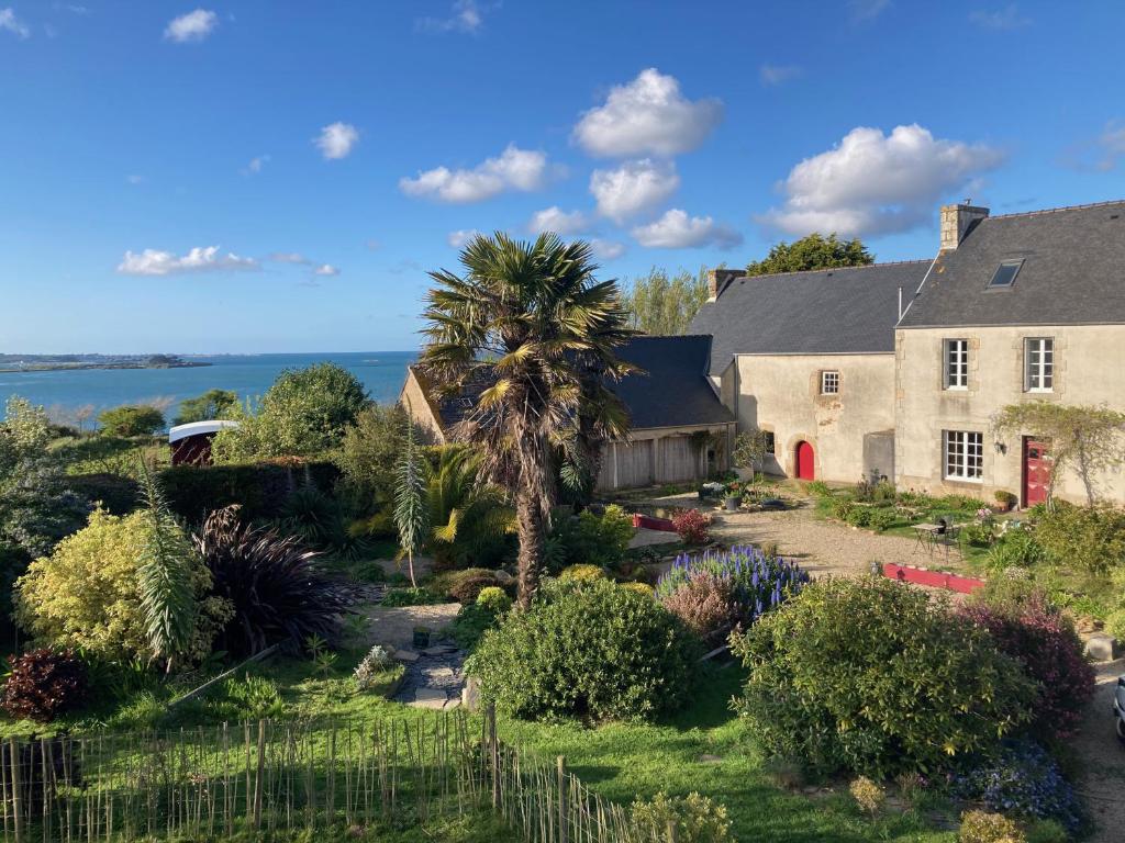 a house with a garden and a palm tree at Les Chambres du Mad in Henvic