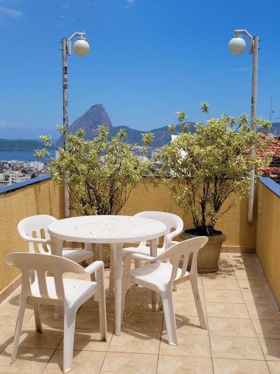 a white table and chairs on a balcony at Santo Mirante Hostel in Rio de Janeiro