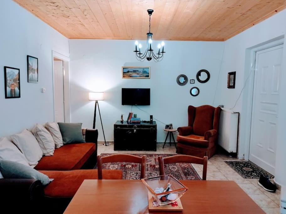 Cozy cottage for 4 في Lávdhas: غرفة معيشة مع أريكة وطاولة