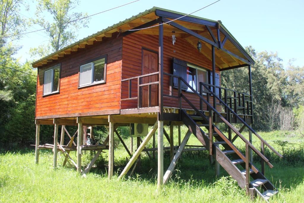 una casa sobre un andamio de madera en un campo en Cabaña El Mahayana en Tigre