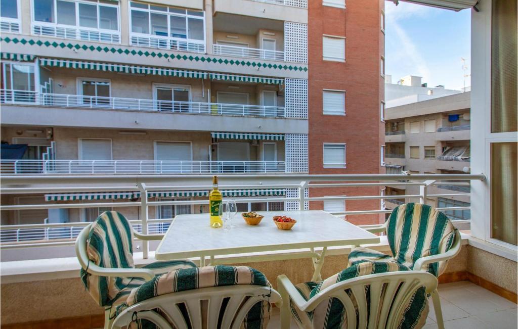 a table and chairs on a balcony with a building at Beautiful Apartment In Santa Pola in Santa Pola