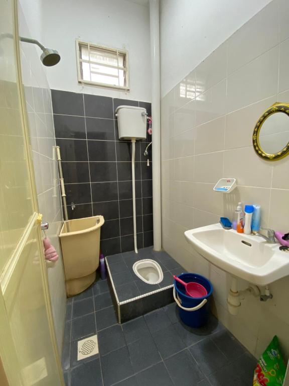 een kleine badkamer met een toilet en een wastafel bij DeSyafiq Homestay in Kuala Kedah