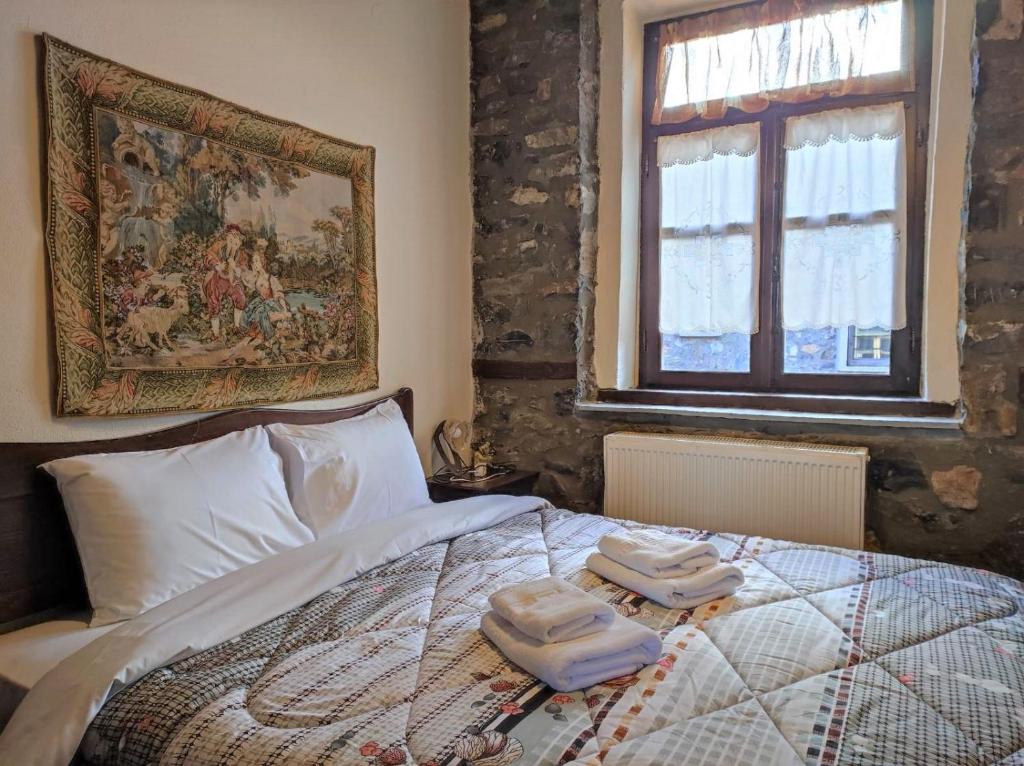 a bedroom with a bed with two towels on it at Μaisonette Christina in Palaios Agios Athanasios