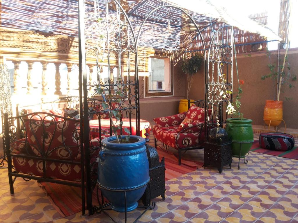 een kamer met een bed, vazen en een bank bij Karim Sahara in Zagora