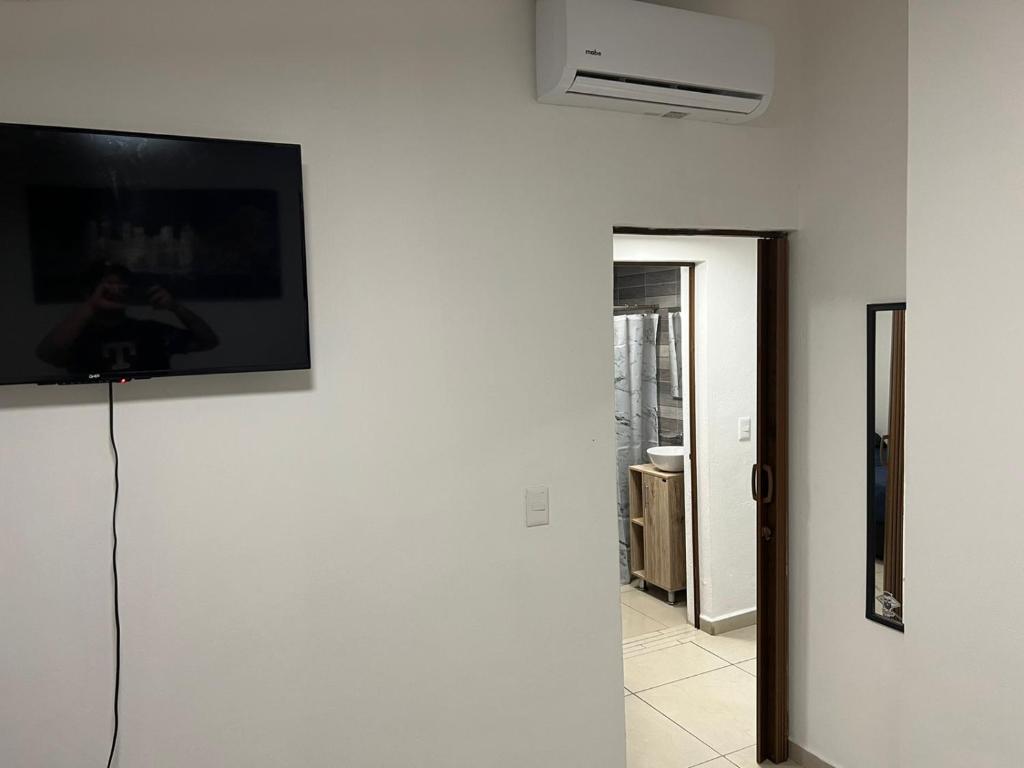 Habitación con TV en la pared en Casa Chito, en Colima