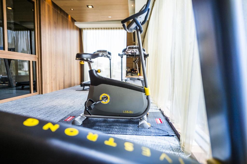 a room with a gym with a treadmill and chairs at In Sky Hotel in Taichung