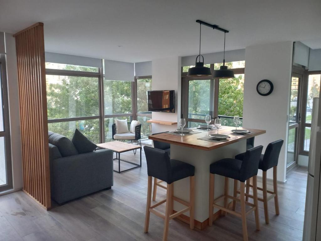 a kitchen and living room with a table and chairs at ALTOS DE STELLA MARIS Excelente Departamento y ubicación in Mar del Plata