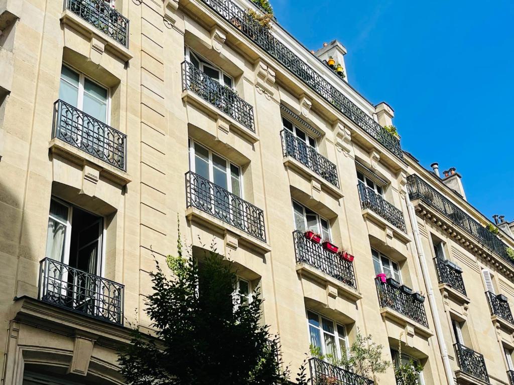 un bâtiment avec des balcons sur le côté dans l'établissement Paris Centre Dernier Étage Vue Ascenseur, à Paris