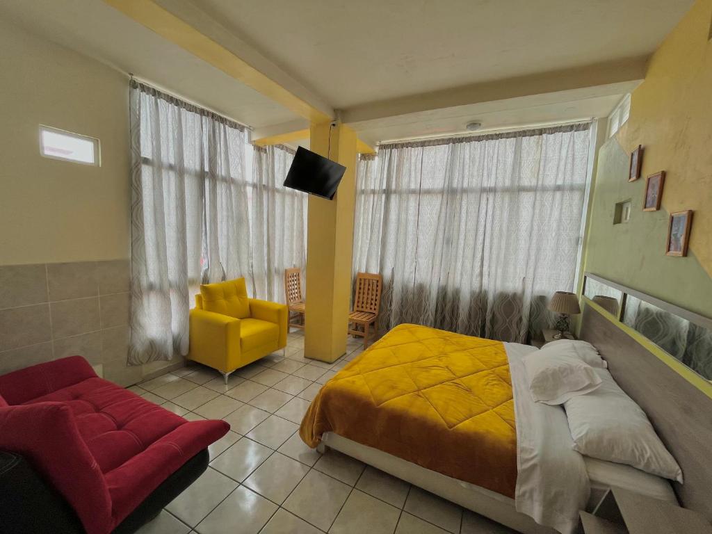 ein Schlafzimmer mit einem gelben Bett und einem gelben Stuhl in der Unterkunft OYO Hotel Museo Carnaval in Huejotzingo