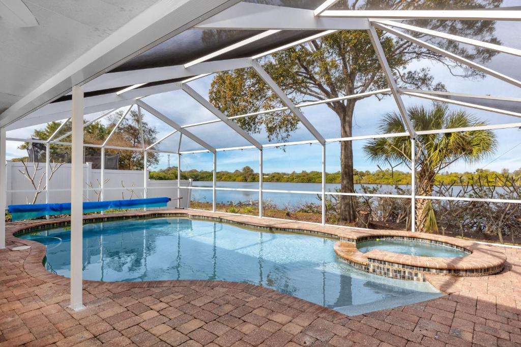 an indoor swimming pool with a large glass house at Blue Heron Lakeview Pool Home Close to Clearwater in Largo