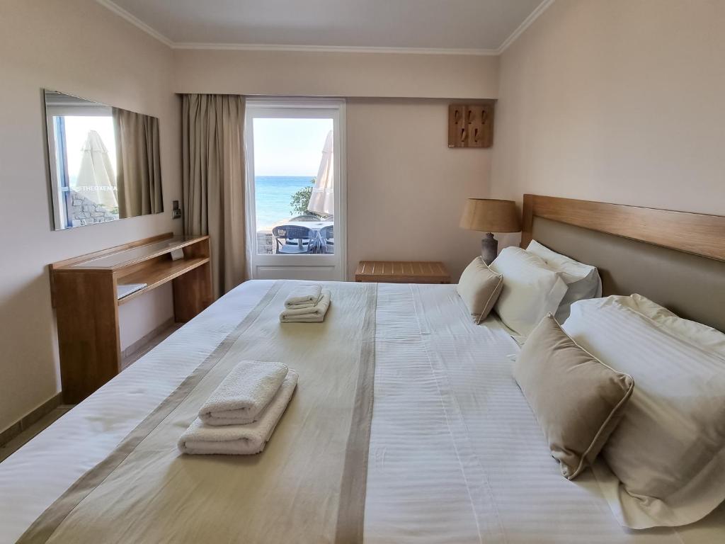 een slaapkamer met een groot bed en handdoeken bij Chios Xenia Studios & Apartments in Paralia Agias Foteinis