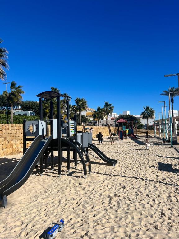 un parque infantil en la playa con un tobogán en Skøn lejlighed med havudsigt og tæt på stranden, en Torreguadiaro
