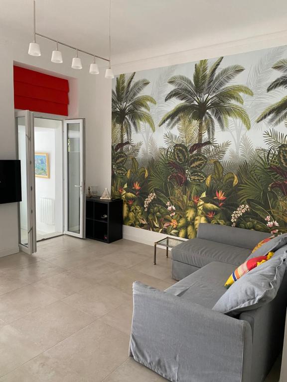 a living room with a mural of palm trees on the wall at LE CAMAS in Marseille