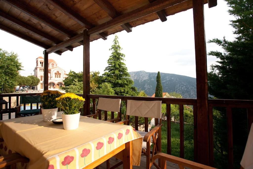 una mesa en un balcón con vistas a la montaña en House in Delphi en Delfoi